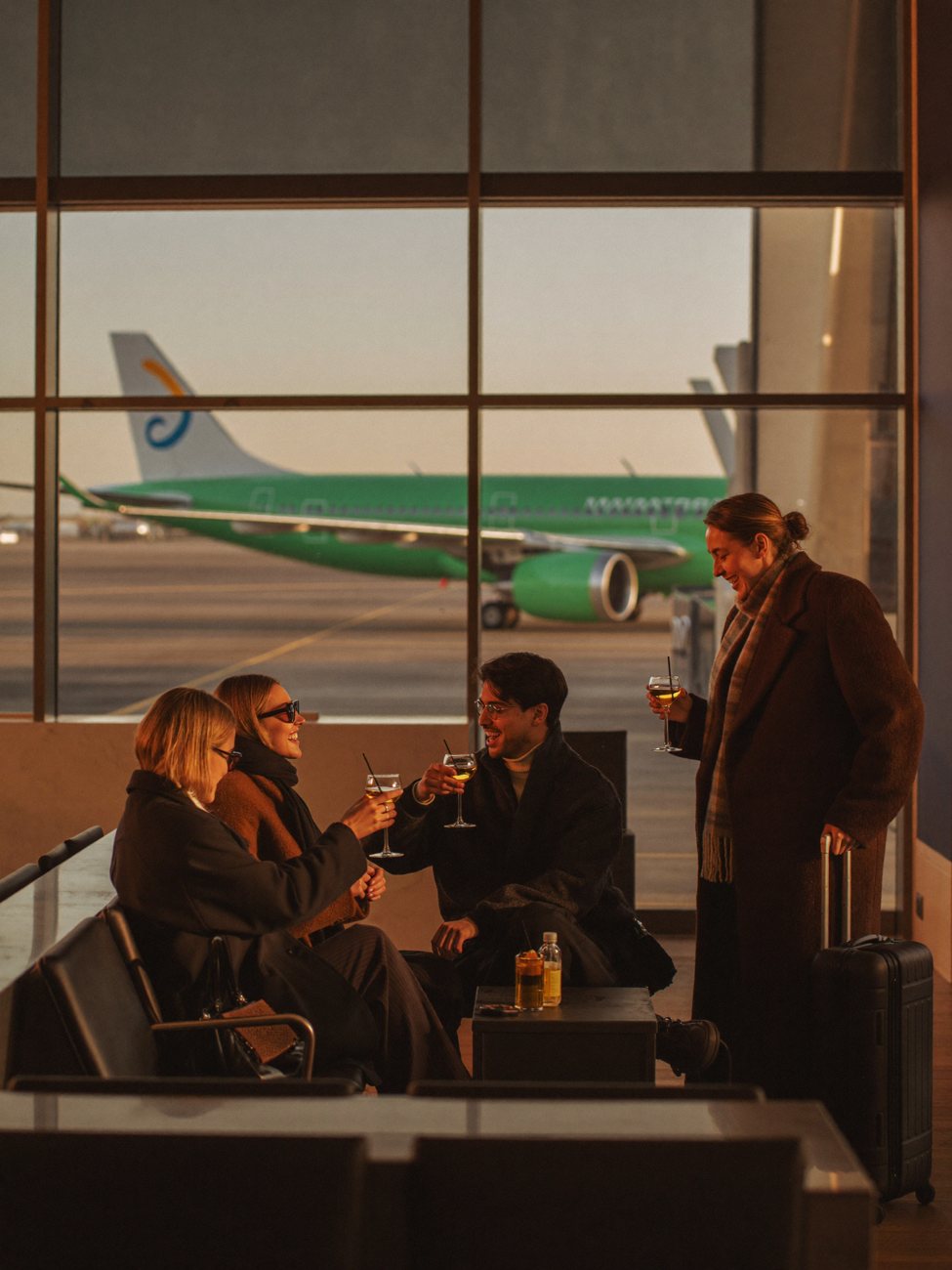Friends toasting cocktails at an airport lounge before a ski trip